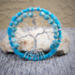 branches seem to be divided equally on the left and right leaving room for a small silver tone moon charm in the middle